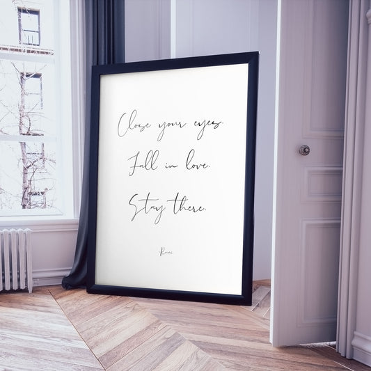 Extra large frame in a luxury, white, minimalist apartment framing a print of a Rumi quote saying 'Close your eyes. Fall in love. Stay here.'